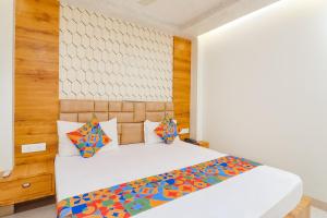 a bedroom with a white bed and wooden walls at FabHotel Holiday Grand in Patna