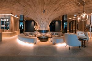 a lobby with couches and a table and chairs at Hotel Steiner Superior in Obertauern