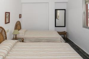 3 łóżka w pokoju z białymi ścianami w obiekcie EL RACO- C, 8-16 w mieście Cullera
