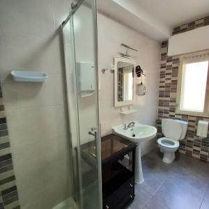 a bathroom with a shower and a sink and a toilet at Pensión Fornos in Caldas de Reis