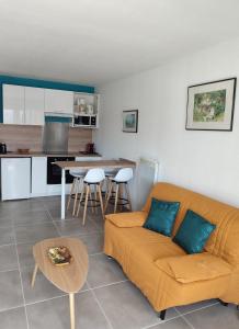 uma sala de estar com um sofá e uma cozinha em Appartement résidence Acapulco vue panoramique port Argeles sur mer em Argelès-sur-Mer