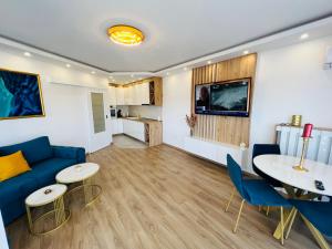 - un salon avec un canapé bleu, une table et des chaises dans l'établissement GRAND LUX Apartment, à Doboj
