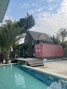 a house with a swimming pool in front of a house at KEPT Cabana เคปท์ คาบานา in Lampang