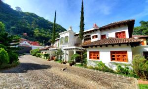 una gran casa blanca con puertas rojas en un camino de grava en Hotel Casa Búho B&B, en Antigua Guatemala
