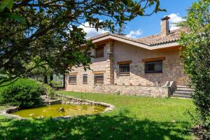 ein Haus mit einem Teich davor in der Unterkunft Lodging Apartments Villa el Raco in Santpedor