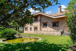 a house with a pond in front of it at Lodging Apartments Villa el Raco in Santpedor