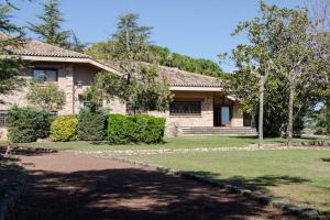 ein Backsteinhaus mit einer Einfahrt davor in der Unterkunft Lodging Apartments Villa el Raco in Santpedor