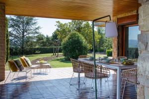 eine Terrasse mit einem Tisch und Stühlen auf einer Terrasse in der Unterkunft Lodging Apartments Villa el Raco in Santpedor