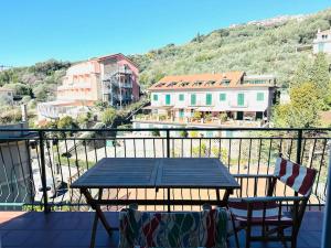 Una mesa y sillas en un balcón con vista. en Casa Delfina, en Tellaro