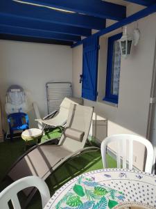 um pátio com cadeiras, uma mesa e uma janela em Appartement résidence Acapulco vue panoramique port Argeles sur mer em Argelès-sur-Mer