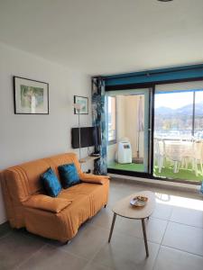 uma sala de estar com um sofá e uma mesa em Appartement résidence Acapulco vue panoramique port Argeles sur mer em Argelès-sur-Mer