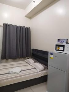 een kleine kamer met een bed en een magnetron bij SMDC Breeze Residences in Manilla