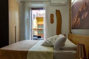 1 dormitorio con cama y ventana en Le Coccinelle Home, en Mandello del Lario