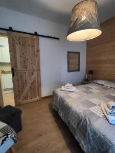 1 dormitorio con 1 cama grande y puerta de madera en Piccolo Appartamento Casa Vacanze B&B Angela, en Clusone