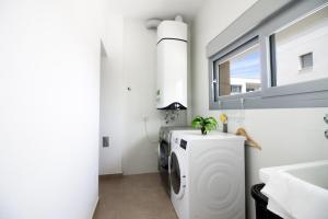 a laundry room with a washing machine and a window at Villa Malibu 3021 in Vistabella
