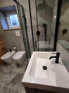 La salle de bains est pourvue d'un lavabo, de toilettes et d'une douche. dans l'établissement Piccolo Appartamento Casa Vacanze B&B Angela, à Clusone