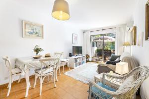 a living room with a table and chairs and a couch at Bouganvillea in Port de Soller