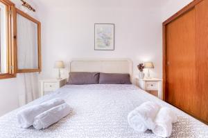 a bedroom with a large bed with two towels on it at Bouganvillea in Port de Soller