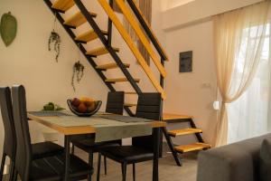 a dining room with a table and chairs and a staircase at GK Home II part of GK FITNESS CLUB in Faliraki