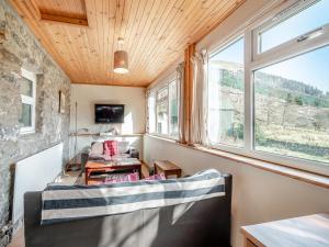 a living room with a couch and a window at Stonefield Farm Cottage in Benmore