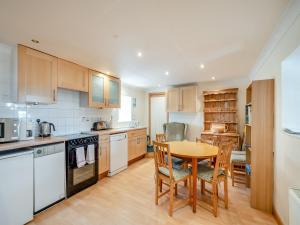 a kitchen with a table and a table and chairs at Stonefield Farm Cottage in Benmore