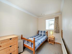 a small bedroom with a bed and a window at Stonefield Farm Cottage in Benmore