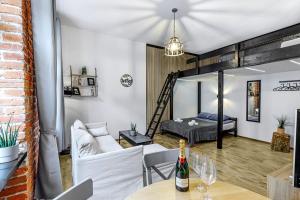 a living room with a bed and a table with a bottle of wine at Rzeźnicza 24 in Wrocław