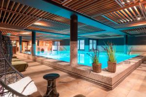 a large swimming pool with plants in a building at Hotel-Restaurant Erbprinz in Ettlingen