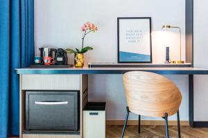 a desk with a laptop and a chair at Resorts World Sentosa - Hotel Ora in Singapore