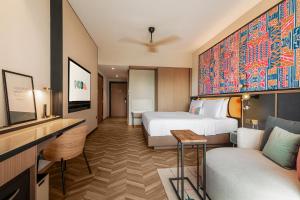シンガポールにあるResorts World Sentosa - Hotel Oraのベッド2台とソファが備わるホテルルームです。