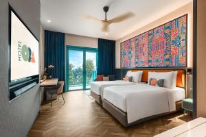 シンガポールにあるResorts World Sentosa - Hotel Oraのベッド2台とテレビが備わるホテルルームです。
