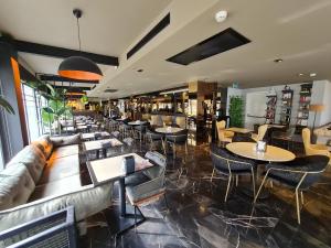 Air Boss Istanbul Airport and Fair Hotel في إسطنبول: مطعم بطاولات وكراسي وأريكة