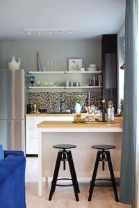 a kitchen with a counter and two bar stools at Moft Loft. Lovely, comfy apartment. in Cluj-Napoca
