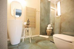 a bathroom with a tub and a toilet and a mirror at Moft Loft. Lovely, comfy apartment. in Cluj-Napoca