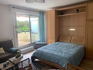 een slaapkamer met een bed en een groot raam bij Grand studio Clémenceau Vue mer 3 étoiles in Pléneuf-Val-André