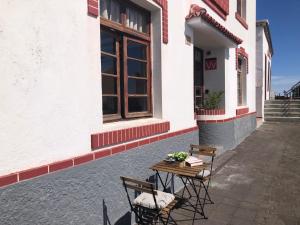 Casa Las Enanitas II (Casa Elias) في فوينكالينتي دي لا بالما: طاولة وكراسي يجلسون خارج المبنى