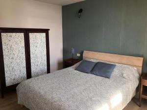 um quarto com uma cama com duas almofadas azuis em Casa Las Enanitas II (Casa Elias) em Fuencaliente de la Palma