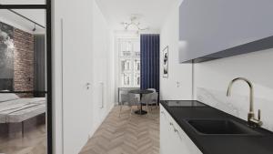 a kitchen with a sink and a bed in a room at Deco Apartments Mariacka 8 in Katowice