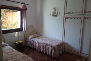 a bedroom with two beds and a window and a dresser at Villa Denise Stintino in Cuile Pazzoni