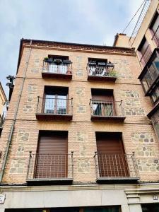 um edifício de tijolo alto com janelas e varandas em Villa Mercedes em Toledo