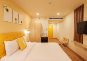 Bloom Hotel - Jalandhar في جالاندهار: غرفة نوم بسرير كبير وتلفزيون