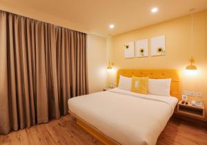 a bedroom with a large bed and a large window at Bloom Hotel - Jalandhar in Jalandhar
