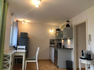 une petite cuisine avec une table, une table et des chaises dans l'établissement Cozy Appartment with Balcony, à Friedrichshafen