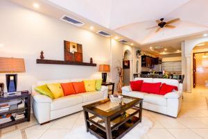 a living room with two couches and a table at Matapalo 104 -2 Bedroom Poolside Condo at the Diria Resort in Tamarindo
