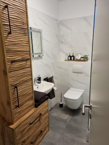 Baño blanco con aseo y lavamanos en Apartment Mara, en Senj