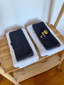 twee handdoeken op een houten blad met een schaar bij Kläve12 Guesthouse in Oldenburg