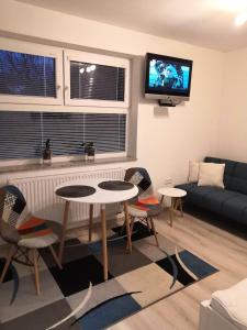 ein Wohnzimmer mit Sofa, Tischen und einem Fernseher in der Unterkunft Privát SIMBA in Strečno