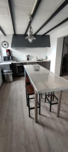 uma cozinha com uma grande mesa branca num quarto em Chez Marie à 5kms de St Valery sur Somme em Pendé