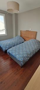 2 łóżka w sypialni z drewnianą podłogą w obiekcie Chez Marie à 5kms de St Valery sur Somme w mieście Pendé