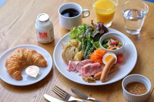 una mesa con dos platos de comida y una taza de café en KUMU Kanazawa by THE SHARE HOTELS, en Kanazawa